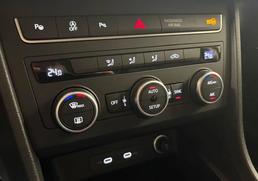 Vue rapprochée du tableau de bord du SEAT Ateca 2024, avec commandes de climatisation digitale et boutons fonctionnels.
