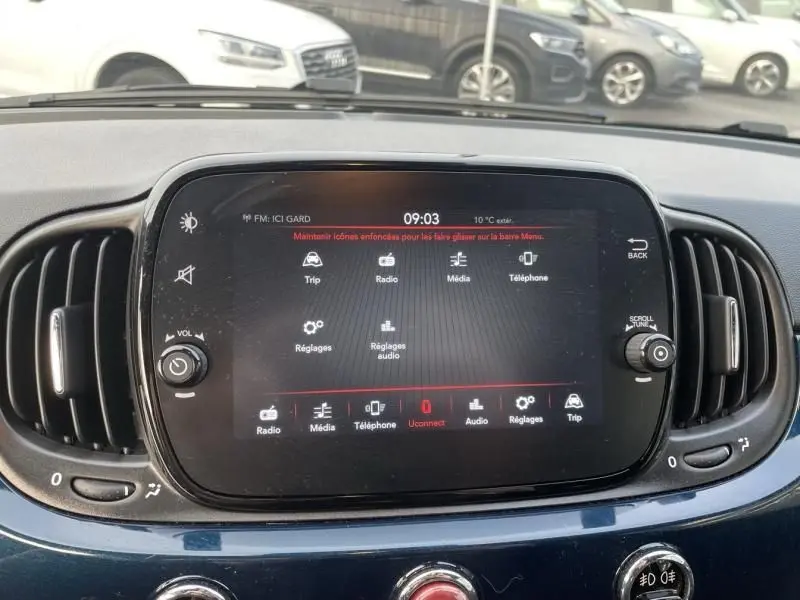Écran tactile central du tableau de bord d’une Fiat 500 bleu métal 2023, affichant le menu multimédia.