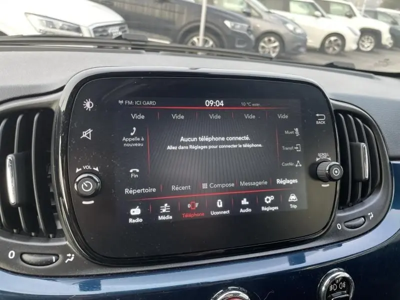 Vue rapprochée de l’écran tactile central du tableau de bord bleu métallisé d’une Fiat 500 2023.