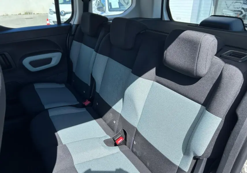 Vue intérieure du siège arrière en tissu bicolore gris et noir du Citroën Berlingo blanc, côté droit ouvert.