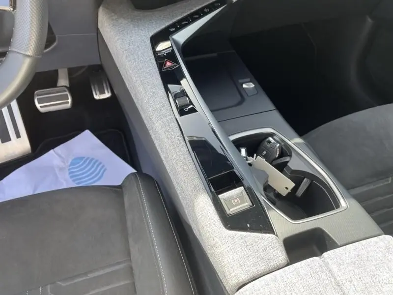 Vue intérieure du Peugeot 3008 2024 gris foncé, focus sur la console centrale avec commandes tactiles et porte-clés visible.