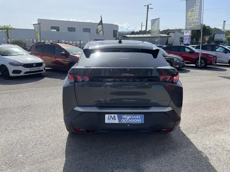 Vue arrière du Peugeot 3008 Nouveau gris foncé 2024, avec feux arrière distinctifs et badge hybride visible.