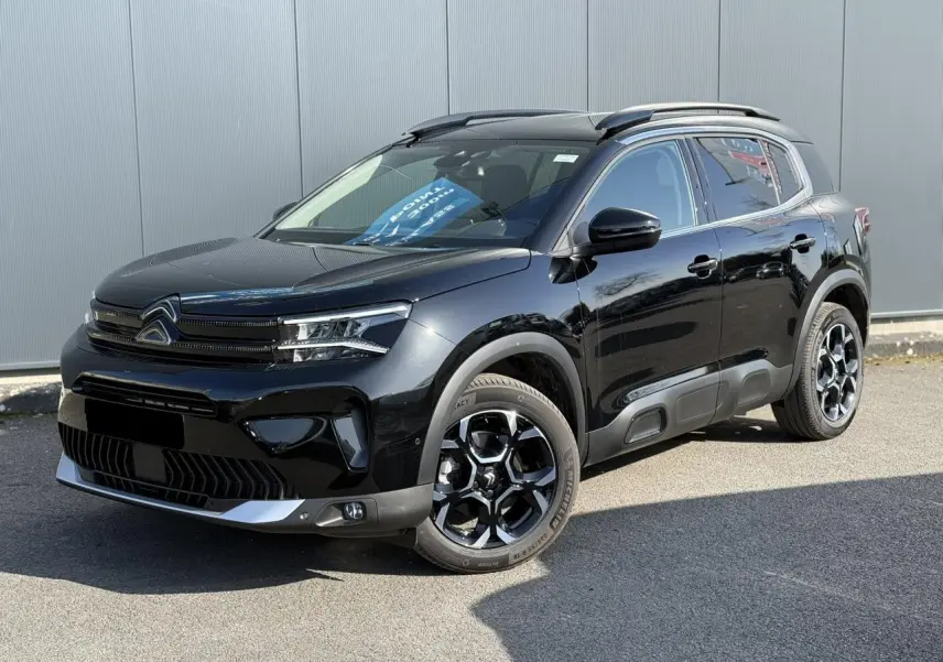 Citroën C5 Aircross 2025 noir Perla en 3/4 avant droit, jantes alliage bi-ton et barres de toit noires brillantes.