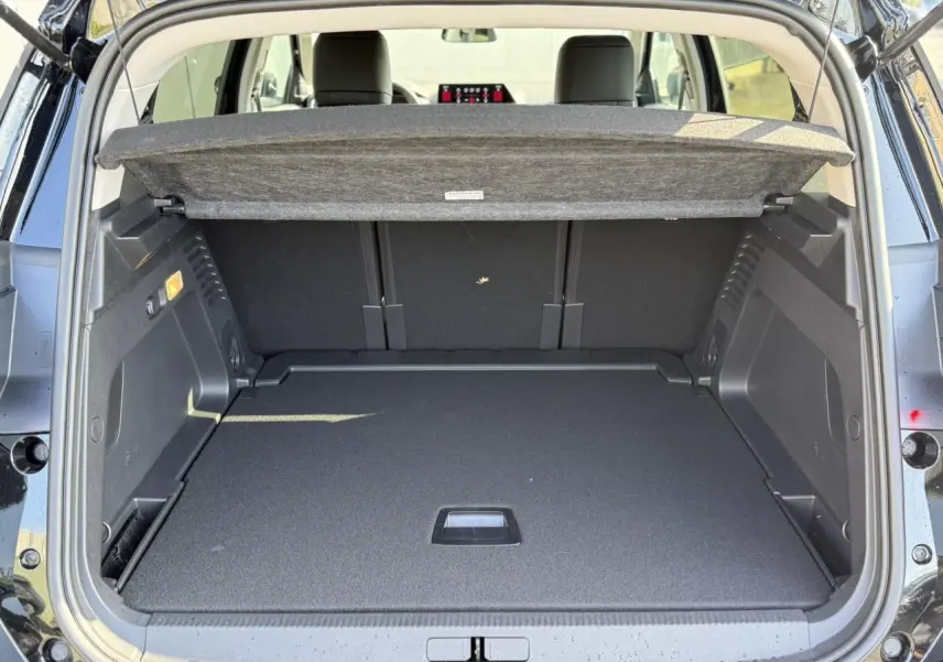 Vue arrière du coffre ouvert d'un Citroën C5 Aircross noir Perla, montrant l'espace de chargement et la tablette cache-bagages.
