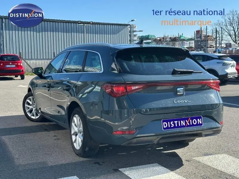 Vue 3/4 arrière droite d’une SEAT LEON ST 2.0 TDI 115ch STYLE XL bleu saphir métallisé, avec feux arrière continus.