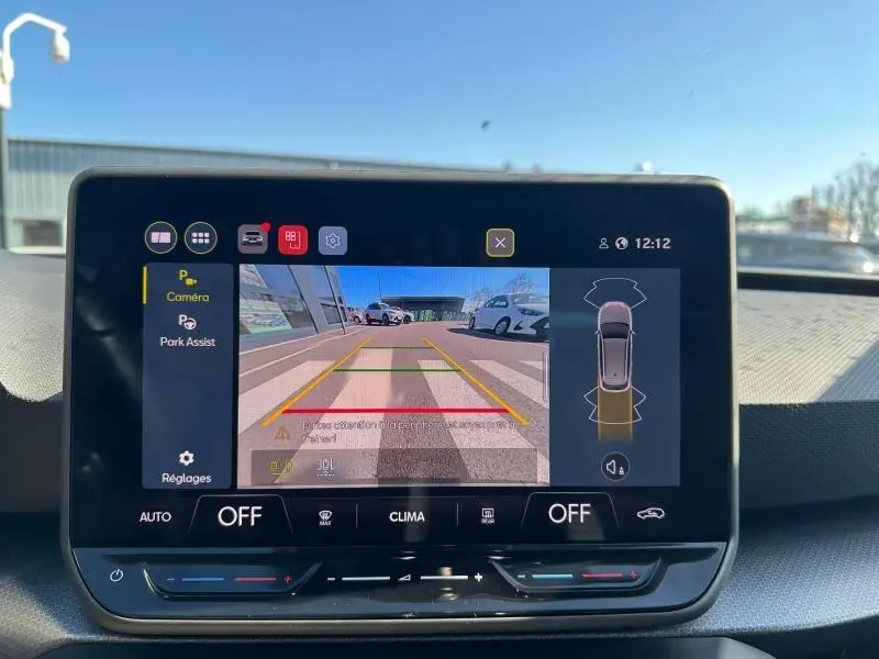 Écran central montrant la caméra de recul d'une SEAT LEON ST 2025, avec vue arrière et lignes de guidage colorées.