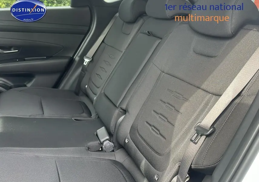 Vue intérieure côté droit sur la banquette arrière noire du Hyundai Tucson 2025 hybride blanc Sérénité.