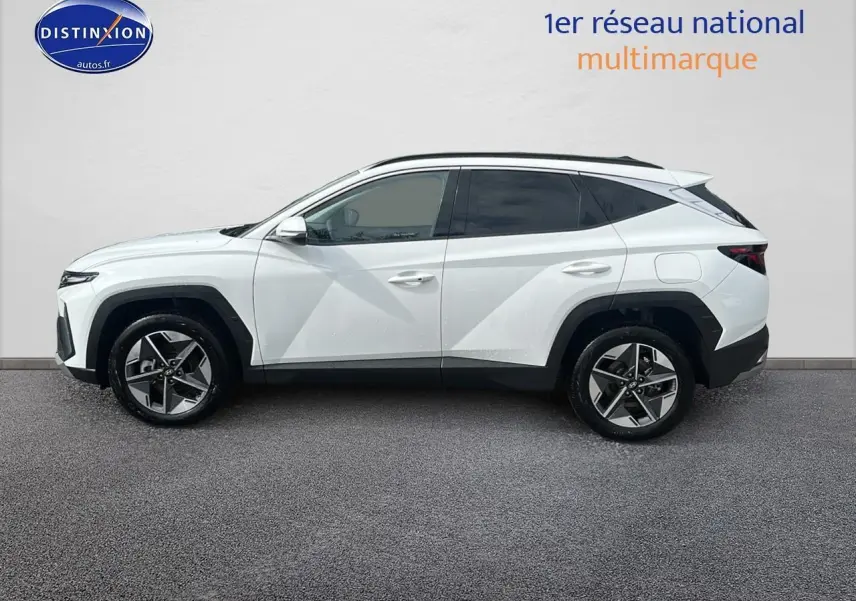 Profil droit d'un Hyundai Tucson blanc Sérénité 2025 avec jantes alliage 18 pouces et vitres teintées.