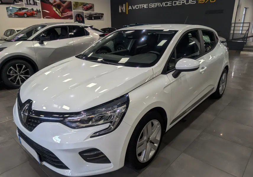 Renault Clio V TCe 100 Business blanc glacier vue 3/4 avant droit en showroom avec jantes alliage.
