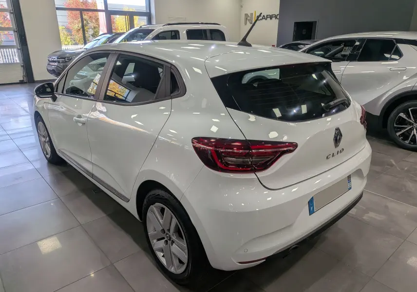 Renault Clio V TCe 100 Business blanc glacier vue 3/4 arrière droit en intérieur showroom lumineux