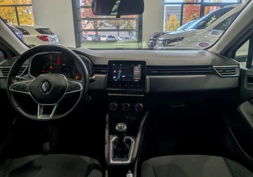 Vue intérieure avant de la Renault Clio V TCe 100 Business 2020, tableau de bord noir avec écran tactile et boîte manuelle.