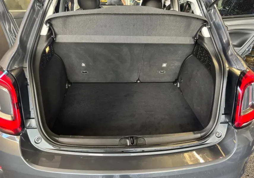 Coffre ouvert vu de l'arrière d'une FIAT 500X MY23 gris, montrant l'espace de chargement vide et la plage arrière.