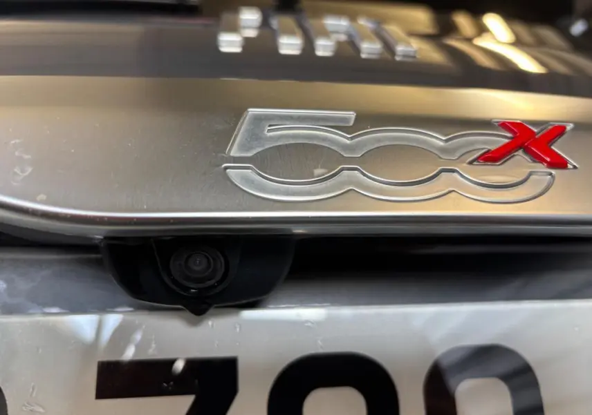 Gros plan sur le logo 500X gris métallisé avec caméra de recul intégrée au-dessus de la plaque d’immatriculation.