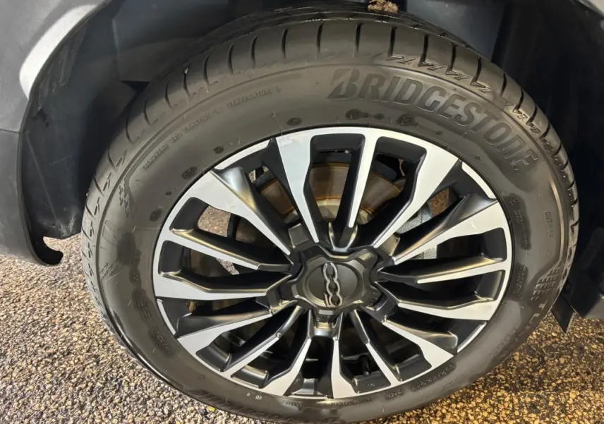Gros plan sur la jante alliage 16 pouces gris foncé du FIAT 500X MY23 avec pneu Bridgestone visible.