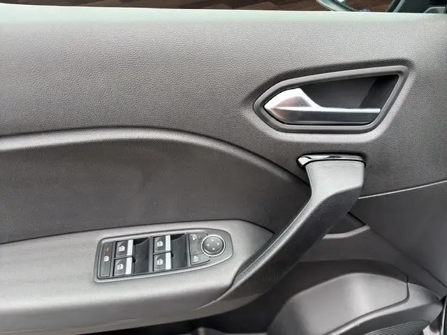 Détail de la porte intérieure côté conducteur de la Renault Symbioz noire, avec commandes des vitres et poignée argentée.