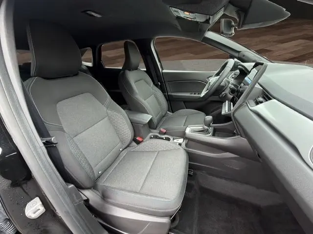 Vue intérieure côté gauche de la Renault Symbioz E-Tech Full Hybrid 145 Evolution 2025, sièges tissu noir et tableau de bord moderne.