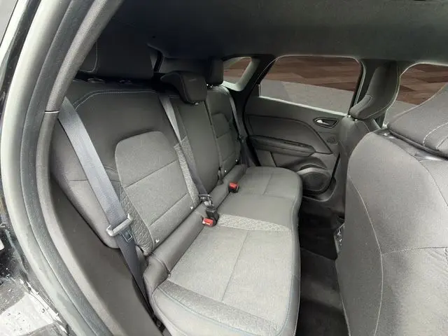 Vue intérieure arrière côté gauche du Renault SYMBIOZ noir 2025, montrant les sièges arrière en tissu noir avec ceintures de sécurité.