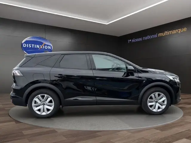 Profil côté droit d'un Renault Symbioz E-Tech Full Hybrid 145 Evolution noir, présenté en intérieur sur un podium circulaire.