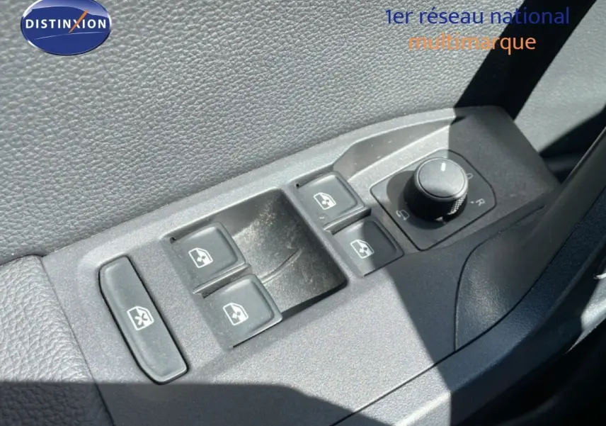 Gros plan sur les commandes de lève-vitres et réglage des rétroviseurs côté conducteur du SEAT Arona noir intérieur.