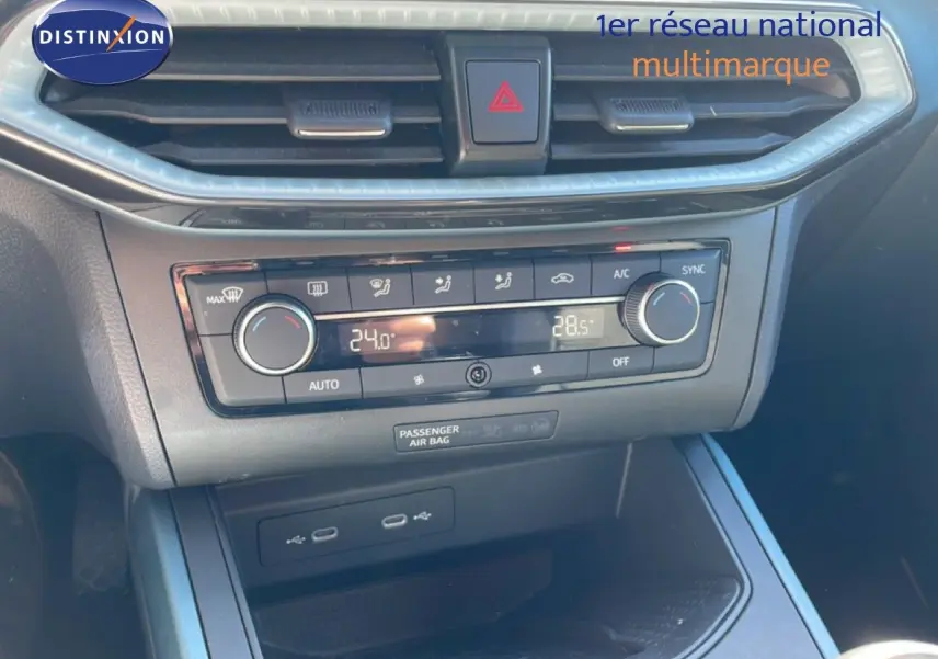 Vue rapprochée de la console centrale du SEAT Arona 2025, avec commandes climatisation et ports USB visibles.