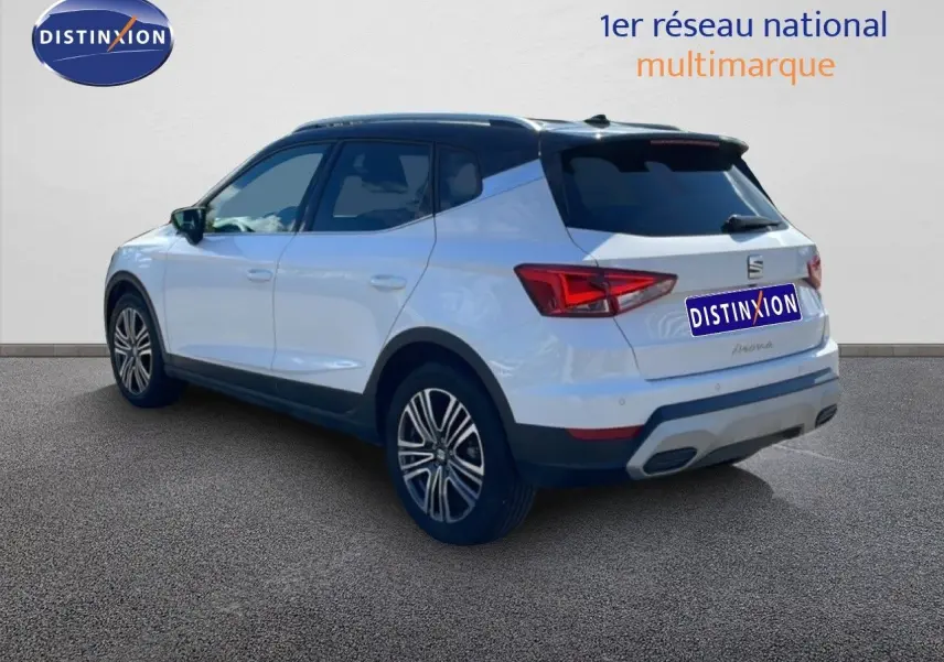 Vue 3/4 arrière droite d'un SEAT Arona 2025 blanc magnétique avec toit noir et jantes alliage.