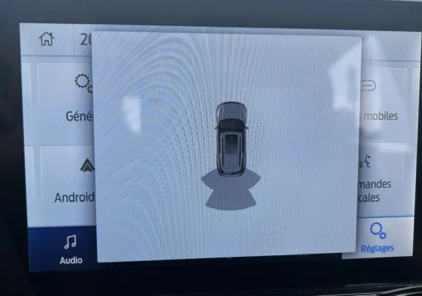 Affichage écran intérieur montrant la vue de dessus du Ford Puma gris Magnetic en mode aide au stationnement.