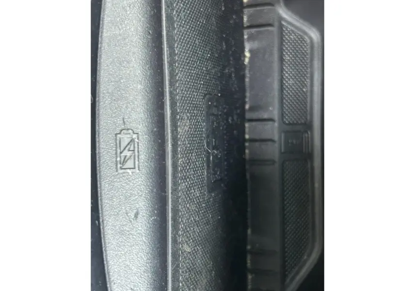 Gros plan sur le seuil de porte intérieur noir avec symbole batterie, Ford Puma gris Magnetic 2022.