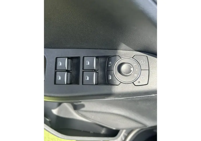 Gros plan sur les commandes de lève-vitres et réglage des rétroviseurs côté conducteur du Ford Puma gris Magnetic 2022.