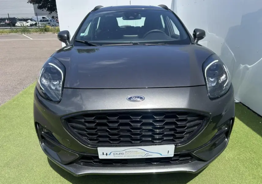 Vue avant d'un Ford Puma gris magnetic avec calandre noire hexagonale et phares LED distinctifs.