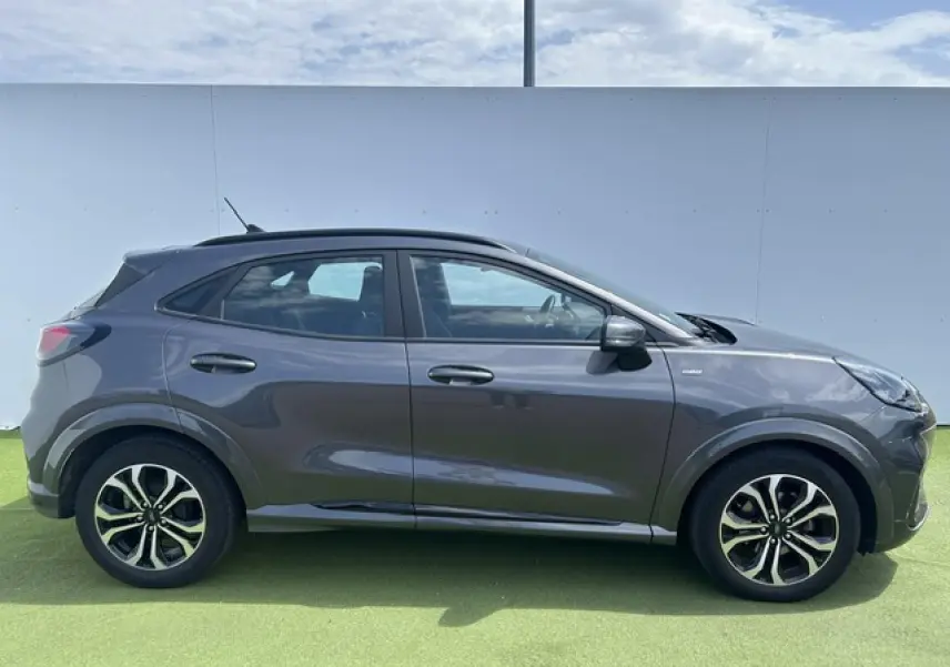 Ford Puma gris Magnetic vue de profil côté gauche, avec jantes alliage et détails noirs sur les passages de roues.