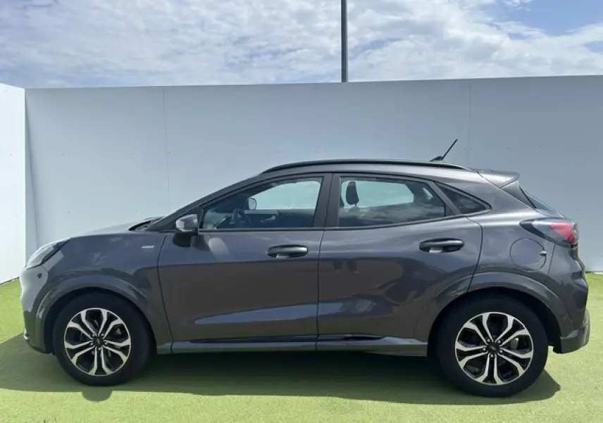 Vue de profil côté gauche d'un Ford Puma gris Magnetic avec jantes alliage et badges ST-Line visibles.