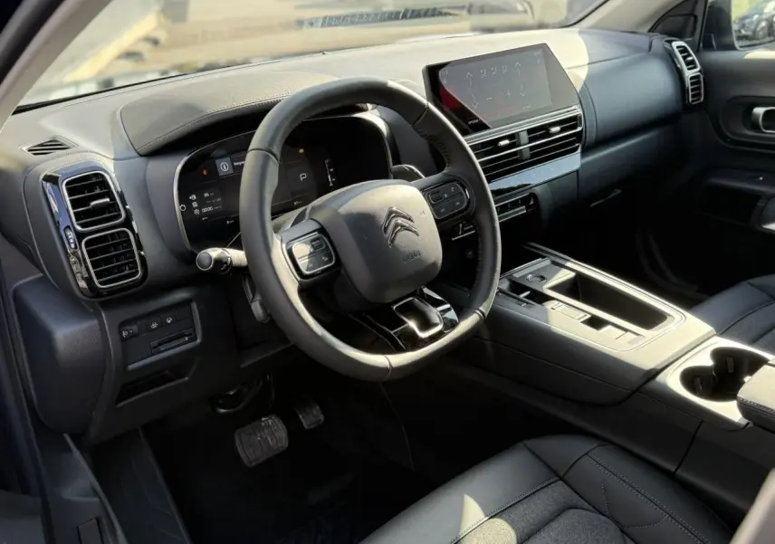 Intérieur noir du Citroën C5 Aircross 2025, vue côté conducteur sur le tableau de bord et écran tactile central.