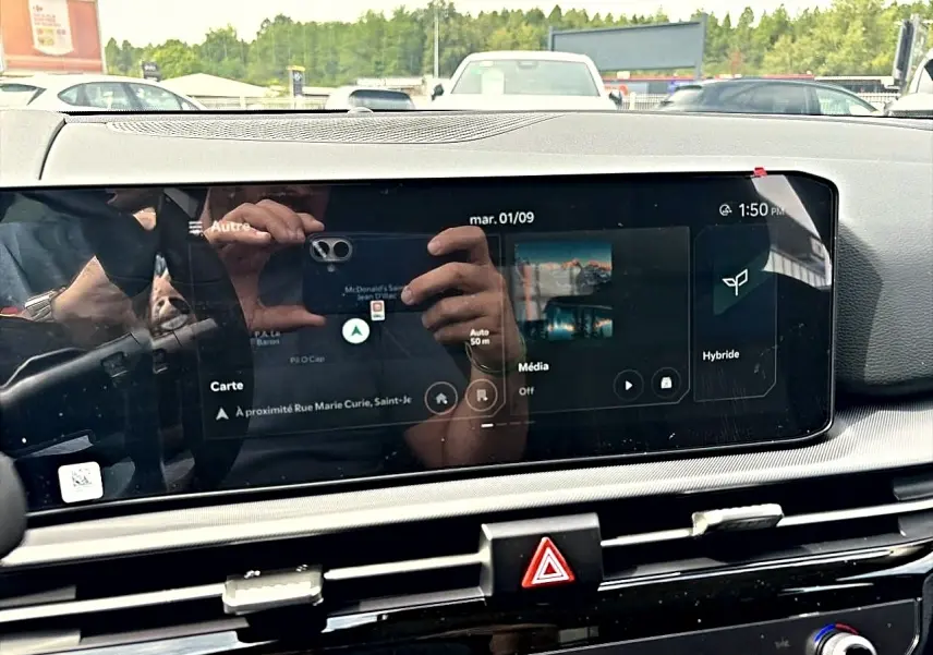 Écran tactile central du Kia Sportage 1.6 hybride 239 gris eclipse, affichant la navigation et mode hybride.