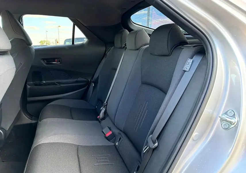 Vue intérieure côté droit sur la banquette arrière gris foncé du Toyota C-HR 1.8 hybride 2025 avec ceinture de sécurité visible.