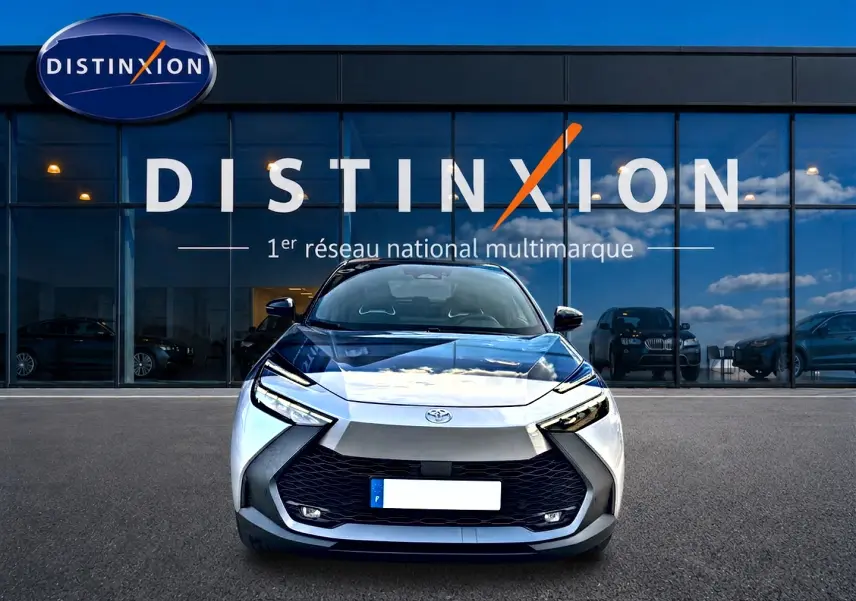 Vue frontale d'un Toyota C-HR 1.8 hybride gris 2025 avec calandre noire et phares LED distinctifs.
