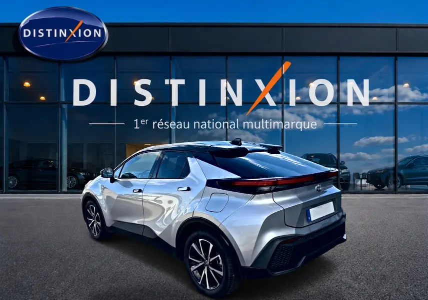 Vue 3/4 arrière droite du Toyota C-HR 1.8 hybride gris métallisé, avec feux arrière LED et jantes alliage noires.