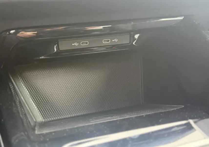 Gros plan sur la console centrale noire de la Volkswagen Golf VIII avec deux ports USB-C intégrés.