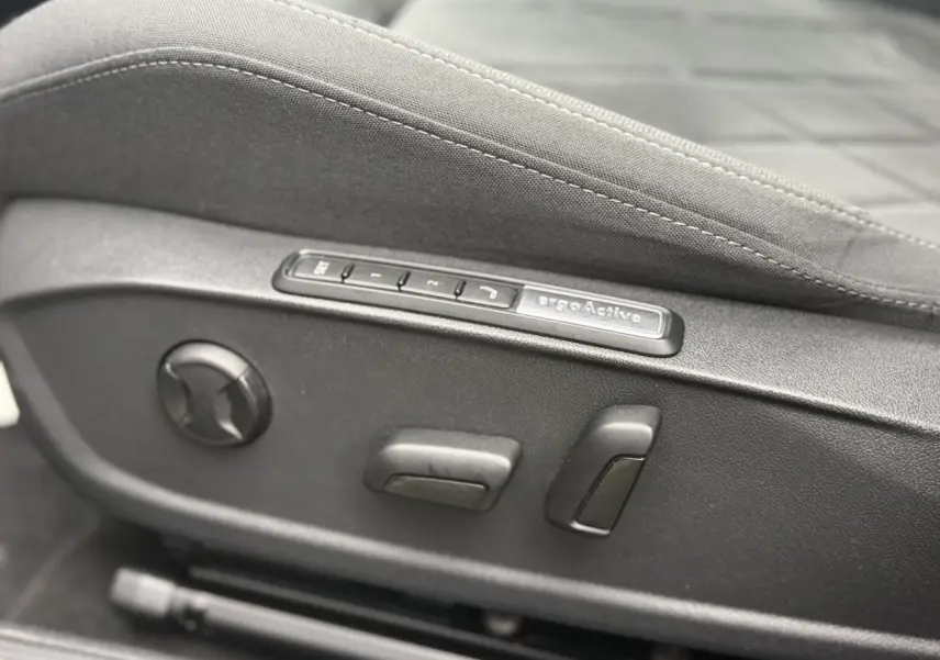 Gros plan sur les commandes électriques du siège ergoActive côté conducteur d'une Volkswagen Golf VIII Deep Black 2024.