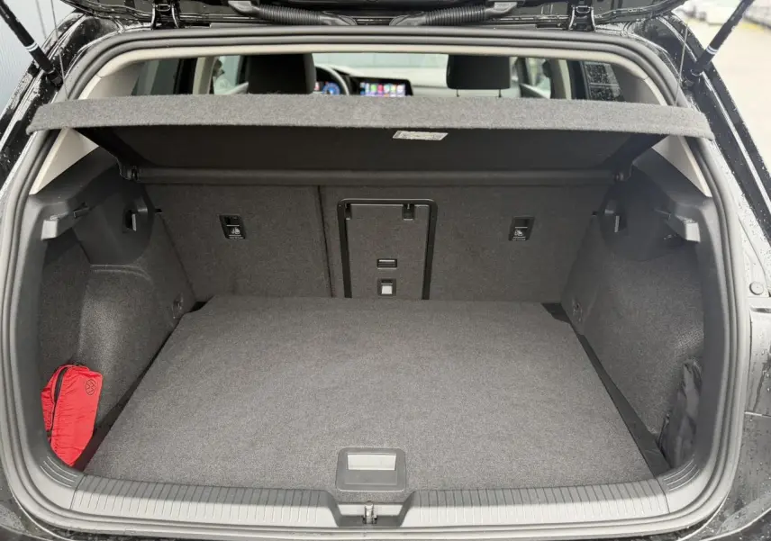 Coffre ouvert vue arrière d’une Volkswagen Golf VIII Deep Black 2024, avec cache-bagages et intérieur gris.