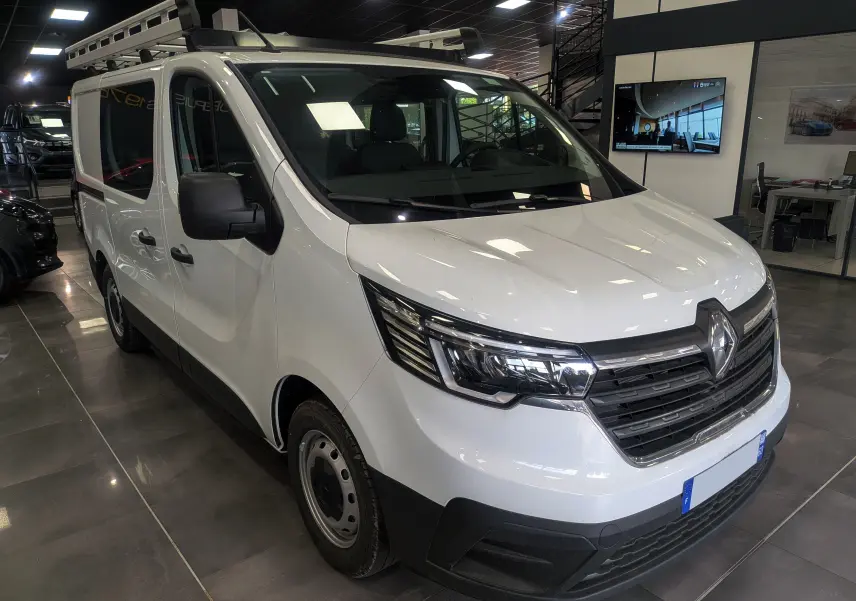 Renault Trafic Cabine Approfondie blanc minéral, vue 3/4 avant droit en showroom avec calandre noire et phares LED.