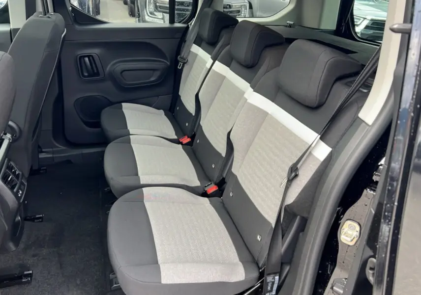 Vue latérale intérieure sur la banquette arrière trois places en tissu gris clair et noir du Citroën Berlingo noir perla nera.