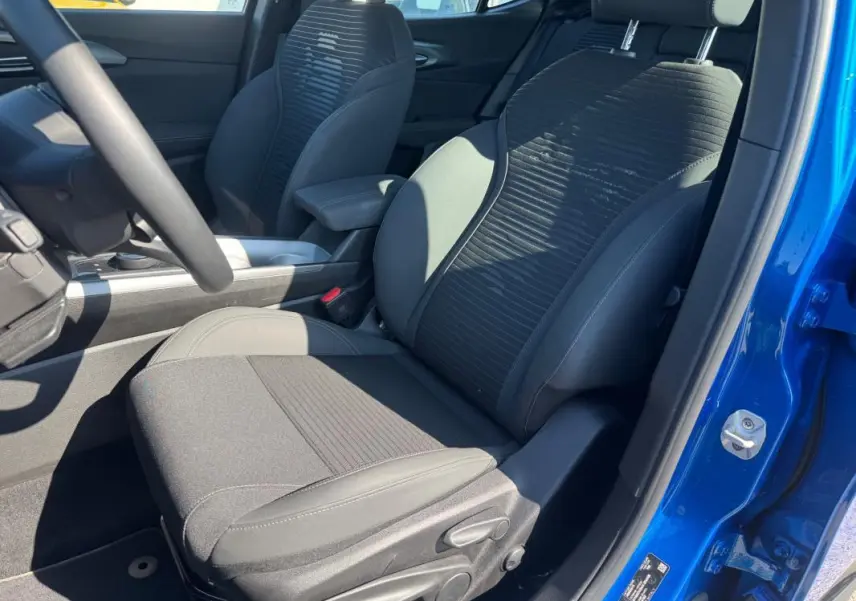 Vue intérieure côté conducteur de l'Alfa Romeo Tonale bleu foncé, montrant le siège sport et l'accoudoir central.