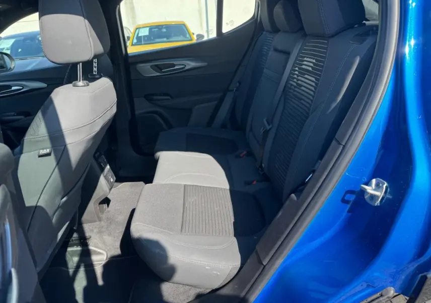Vue intérieure arrière côté droit de l'Alfa Romeo Tonale bleu foncé, montrant les sièges arrière en tissu noir et détails de la porte ouverte.
