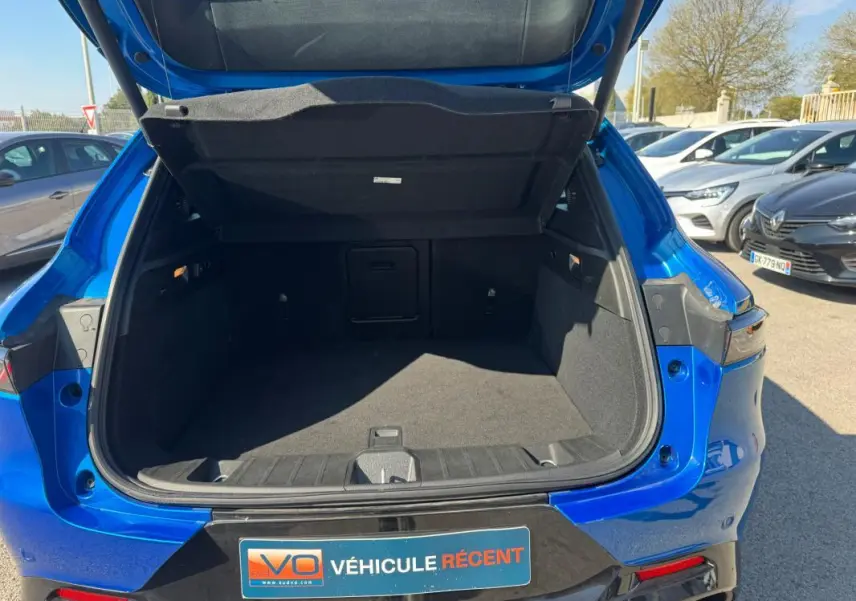 Coffre ouvert vu de l’arrière d’un Alfa Romeo Tonale bleu foncé, avec hayon relevé et intérieur spacieux.