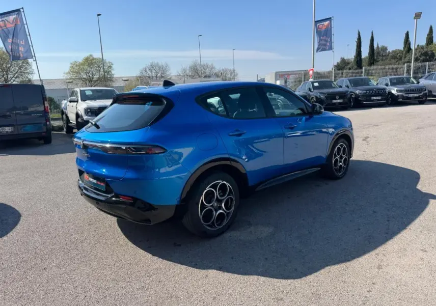 Vue 3/4 arrière droite d'une Alfa Romeo Tonale bleu foncé avec jantes alliage 18 pouces et lignes épurées.