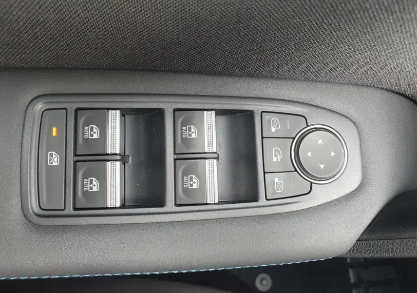 Panneau de commandes des vitres et rétroviseurs sur la portière côté conducteur du Renault Captur bleu Iron 2026.