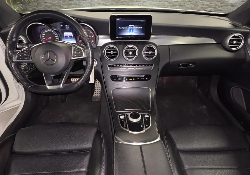 Intérieur noir de Mercedes Classe C Coupé 2017, vue frontale sur tableau de bord et volant multifonction AMG.