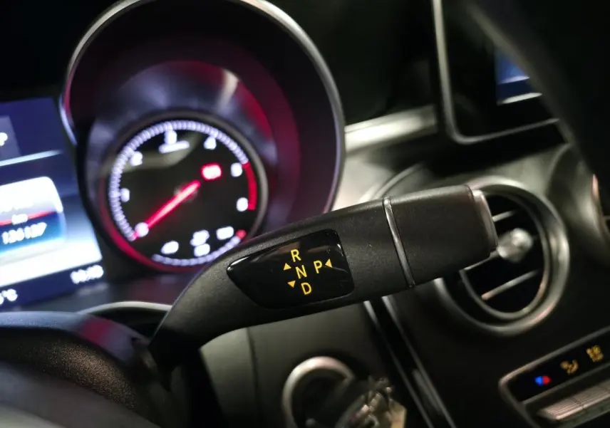 Levier de boîte automatique avec affichage des modes R, N, P, D dans l'habitacle d'une Mercedes Classe C Coupé blanc.