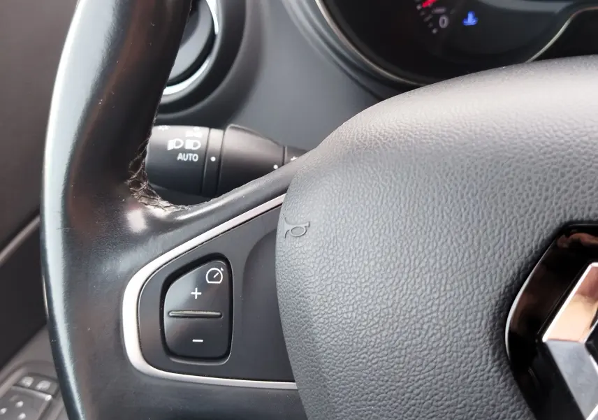Gros plan sur le volant noir du Renault Captur 2018, avec commandes de régulateur de vitesse et logo Renault visible.