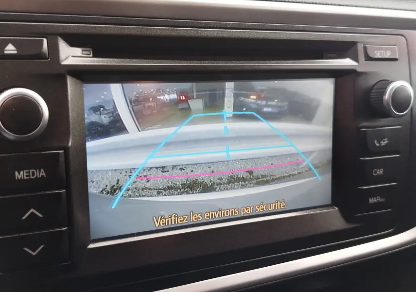 Écran de caméra de recul de la Toyota Auris HSD 136h gris aluminium, affichant les lignes d’aide au stationnement.